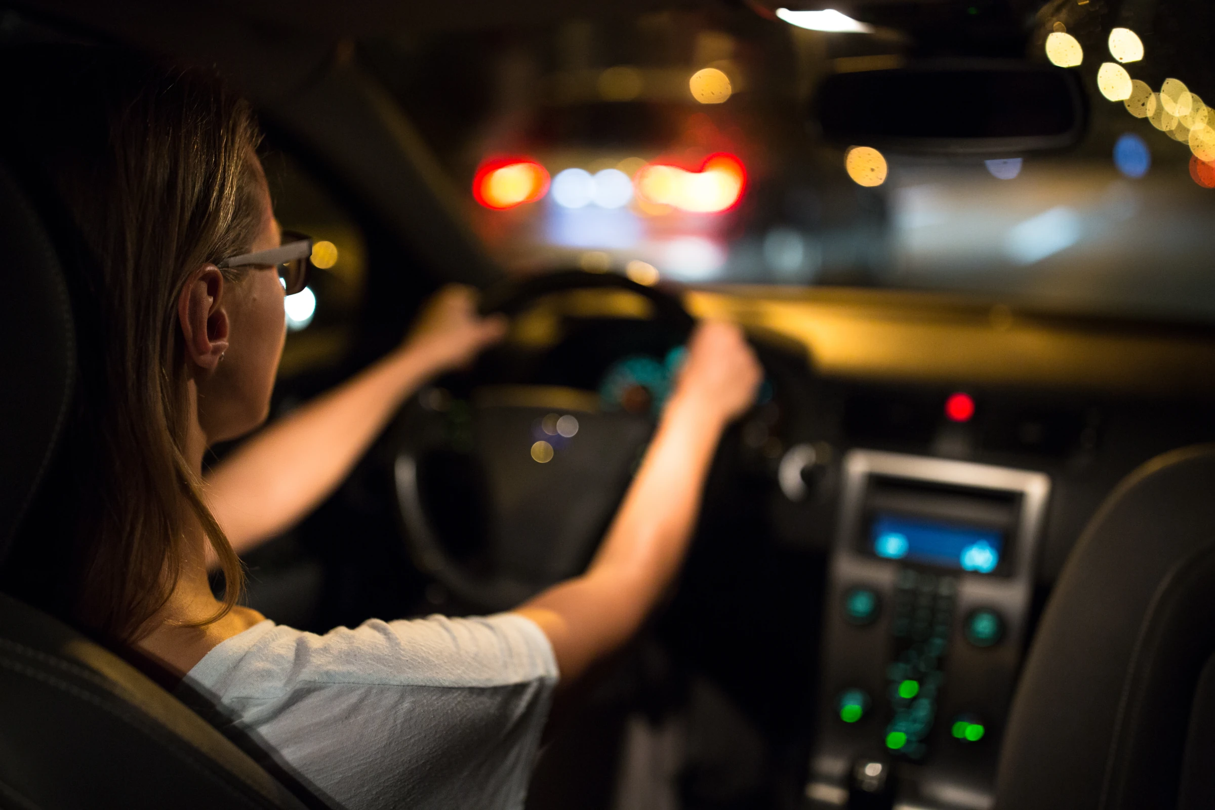 Frau fährt Auto in der Nacht mit ihrer Nachtfahrbrille