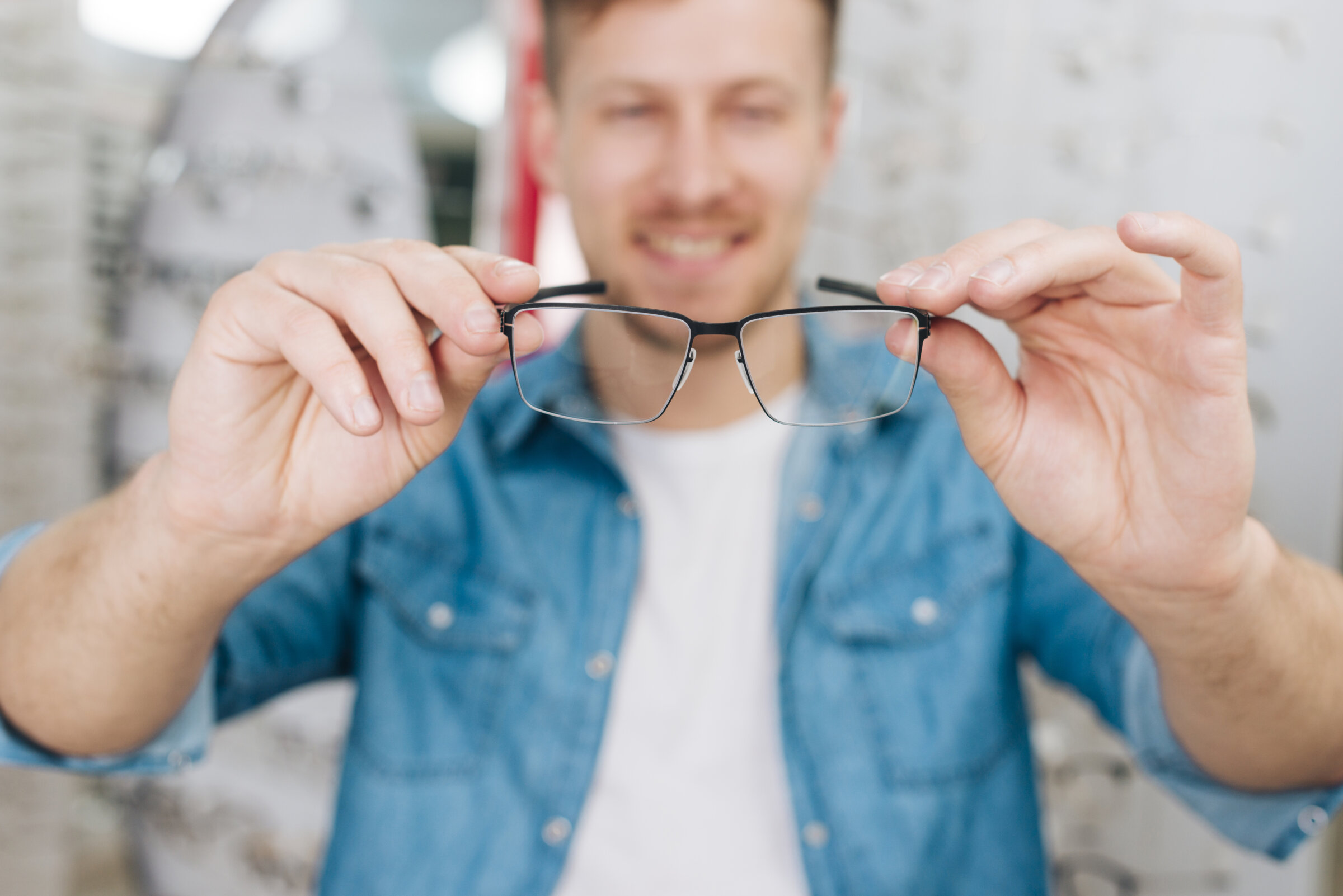 Brille rutscht 3 Mann hält eine Brille mit beiden Händen in Richtung Kamera – Symbolbild für die Wahl einer gut sitzenden Brille beim Optiker.