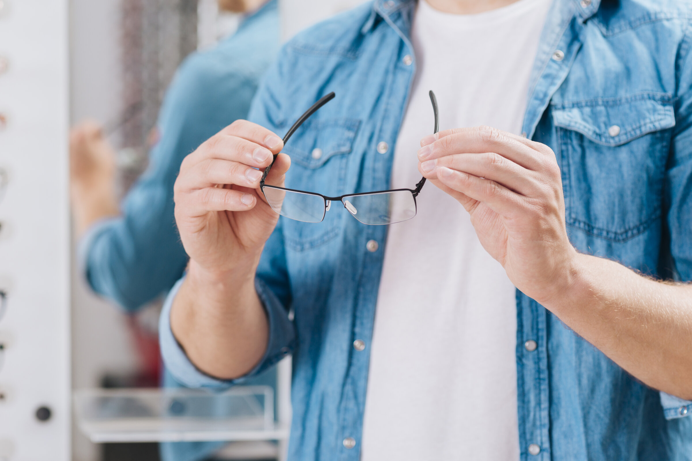 Brille rutscht 4 Mann hält eine Brille auf Augenhöhe vor sich – Symbolbild für die Auswahl einer passenden Brille, die weder rutscht noch drückt.