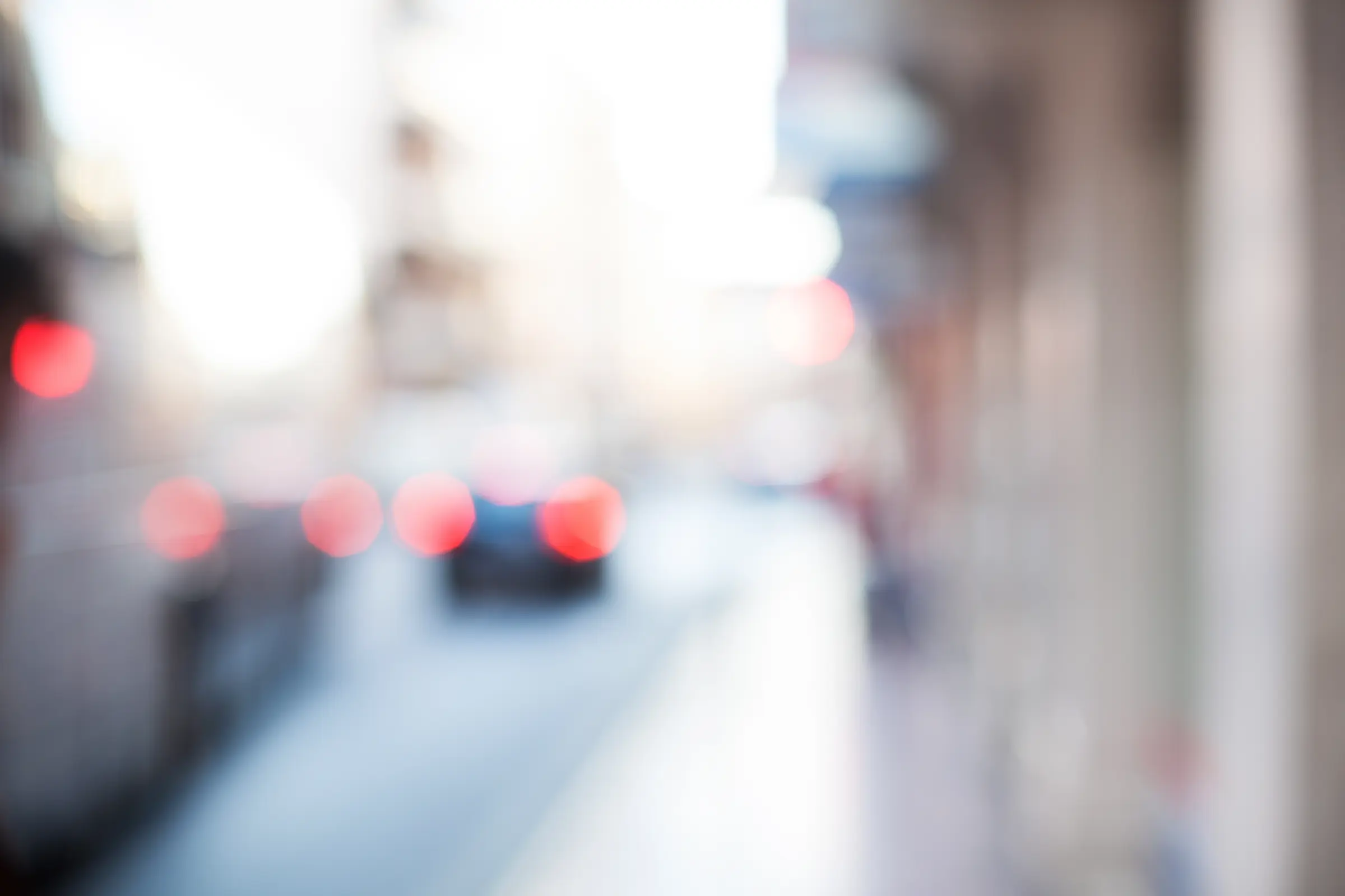 Unscharfe Straßenansicht mit Lichtern und Autos als Beispiel für verschwommenes Sehen bei Hornhautverkrümmung