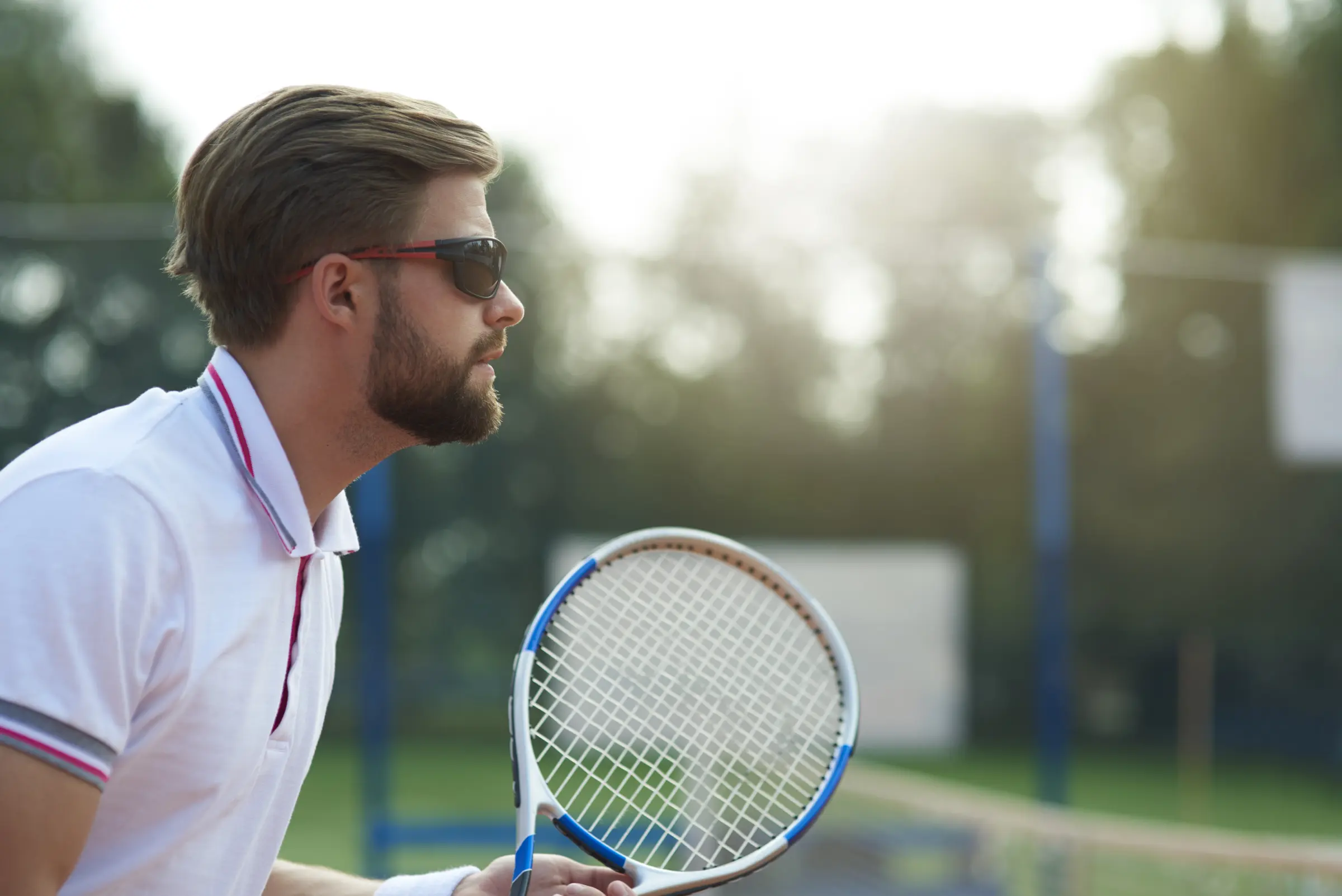 Tennisspieler mit Sportbrille Tennisspieler mit Sportbrille auf dem Tennisplatz – Sportbrille für optimalen Augenschutz und klare Sicht beim Tennis.