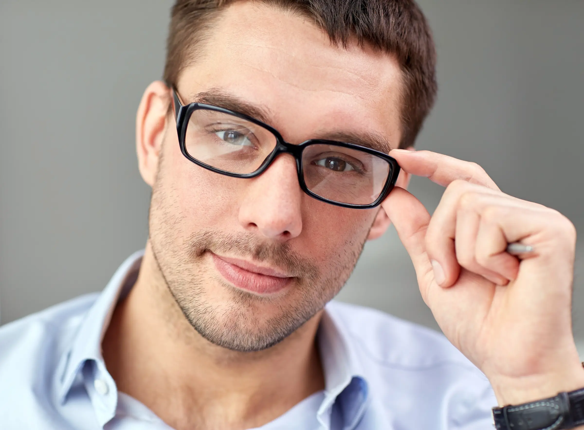 Mann mit schwarzer Brille blickt durch seine Brillengläser